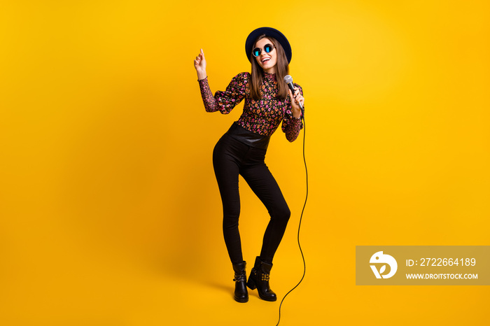Full length body size photo of pop star keeping microphone dancing performing on festival isolated bright yellow color background