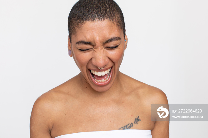 Studio portrait of woman with nose ring laughing