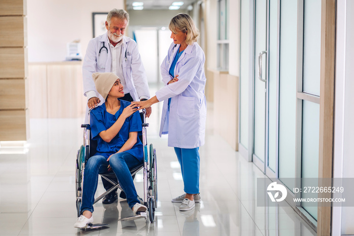 Professional medical doctor team with stethoscope in uniform discussing with patient woman with cancer cover head with headscarf of chemotherapy cancer in hospital.health care concept