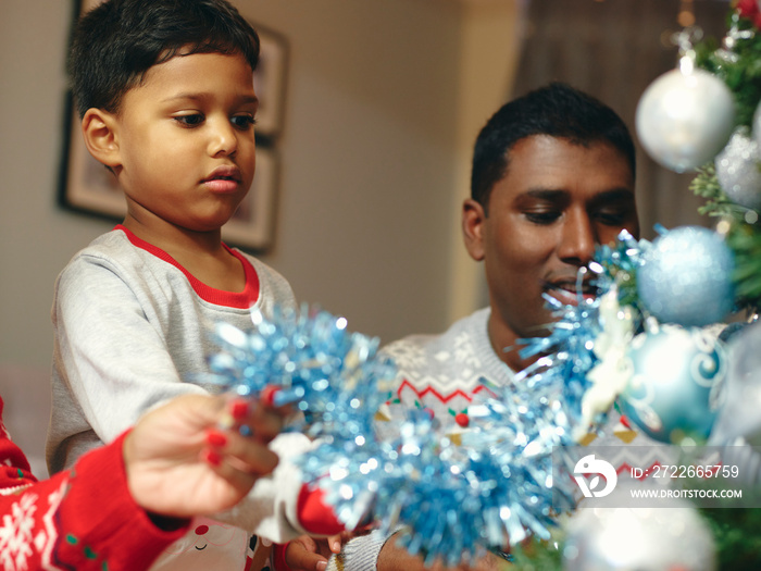 Parents and son decorating Christmas tree