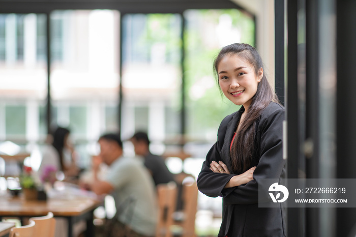 Portrait of smiling young business woman with arm crossed on office