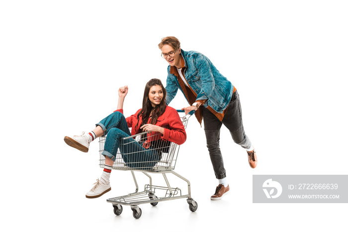 stylish male hipster carrying shopping cart with girlfriend isolated on white