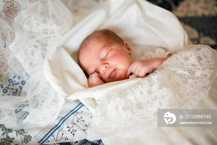 Newborn baby boy in bed. New born child in white bodykit lying in light cradle. Children sleep. Bedding for kids. Infant napping in bed. Healthy little kid shortly after birth