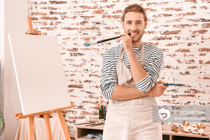 Young male artist painting at home