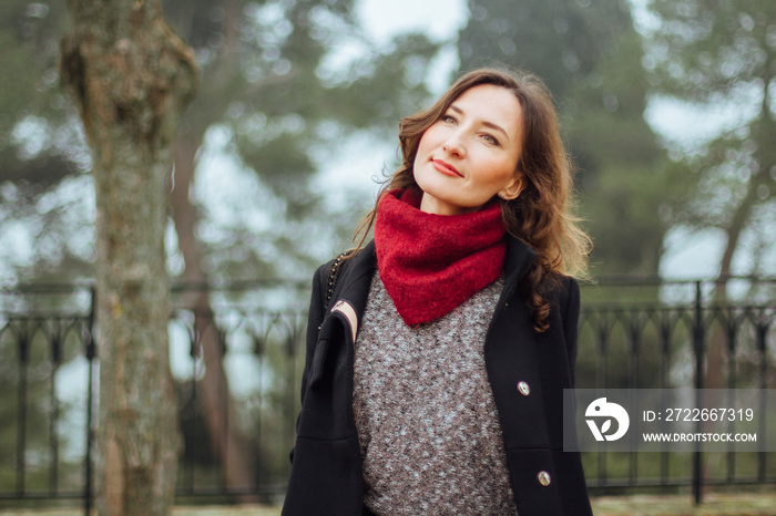 Young romantic and smiling woman on autumn or winter green foggy background