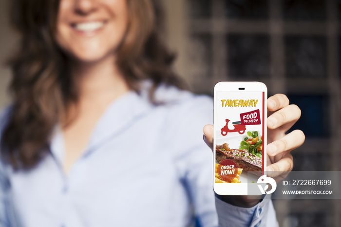 Woman ordering take away food by internet with a mobile phone.