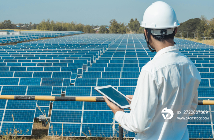 The solar farm(solar panel) with engineers walk to check the operation of the system by laptop, Alternative energy to conserve the world’s energy, Photovoltaic module idea for clean energy production