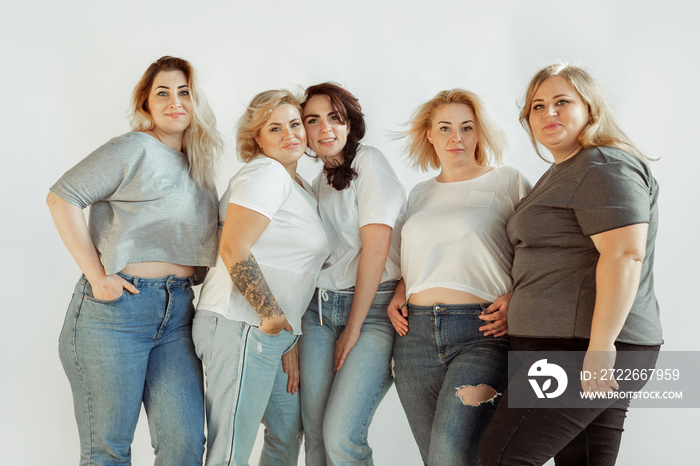 Young caucasian women in casual clothes having fun together. Friends posing on white background and laughting, looks happy, well-kept. Bodypositive, feminism, loving themself, beauty concept.