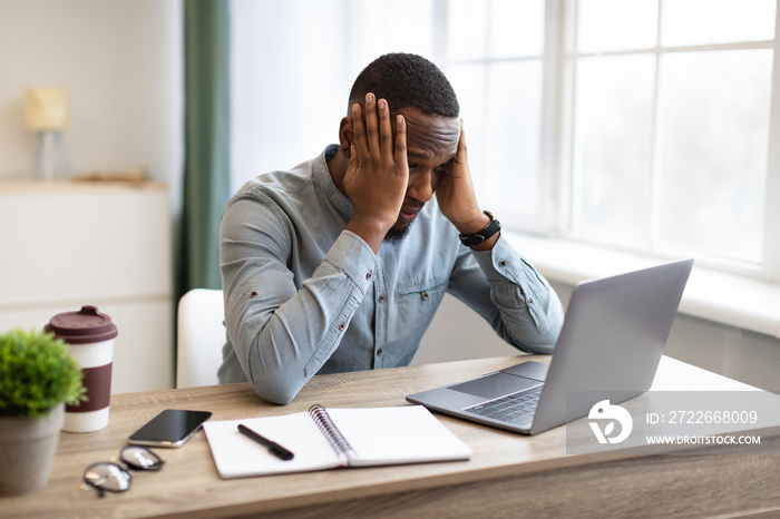 African Businessman At Laptop Touching Head Having Problem At Workplace