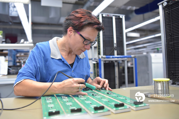 friendly woman working in a microelectronics manufacturing factory - component assembly and soldering