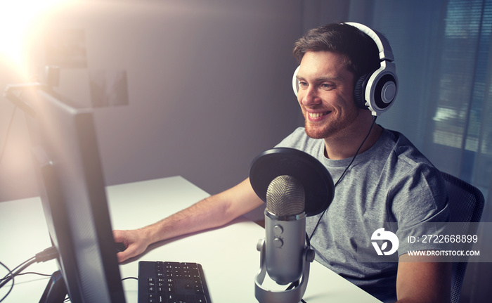 man in headset playing computer video game at home