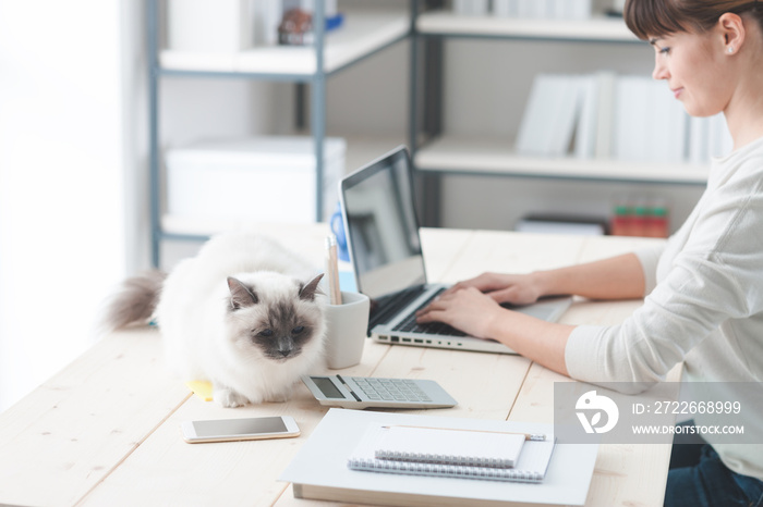 Woman working at desk with her cat