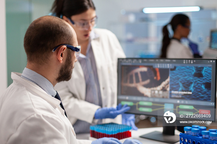 Medical scientist conducting vaccine research against new virus in modern equipped laboratory. Chemists stuff analysing virus evolution using high tech technology for treatment research.