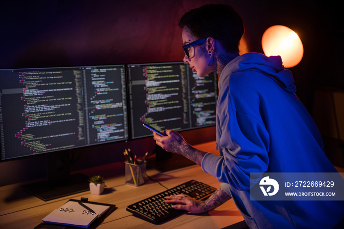 Photo of serious busy it specialist dressed sweatshirt piercing glasses hard working modern devices indoors workplace workstation