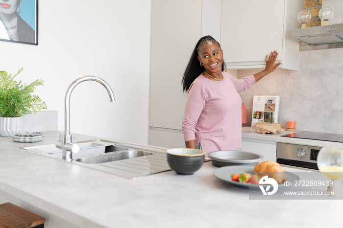 Smiling woman preparing breakfast in kitchen