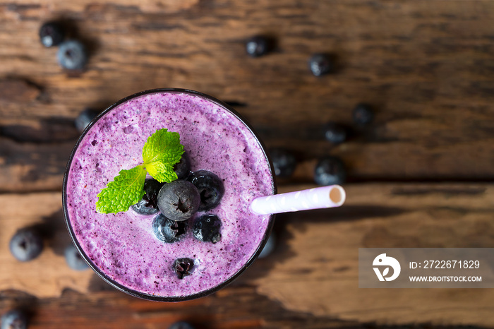 Blueberry smoothie purple colorful fruit juice milkshake blend beverage healthy high protein the taste yummy In glass drink episode morning on a wooden background from top view.