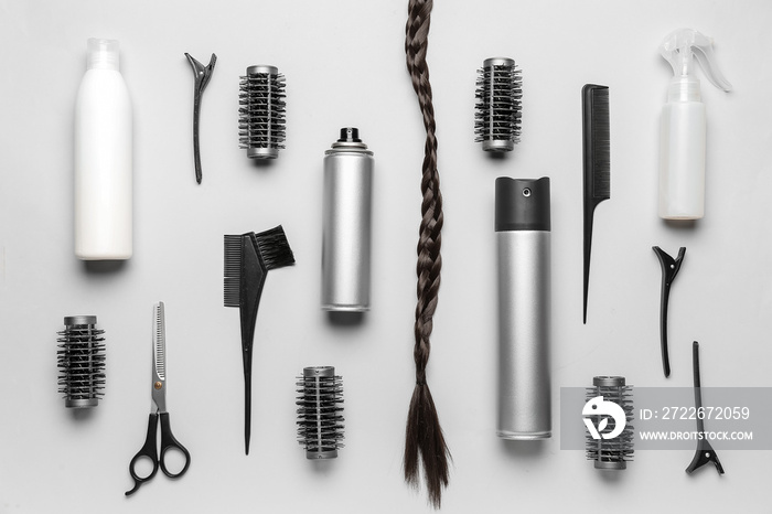 Hair sprays with brushes and braided strand on light background