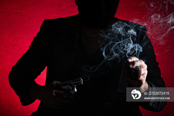 silhouette of business man suit holding smoking pipe on left hand and hiding revolver in right hand like a boss and mafia ready for betray everyone stock photo