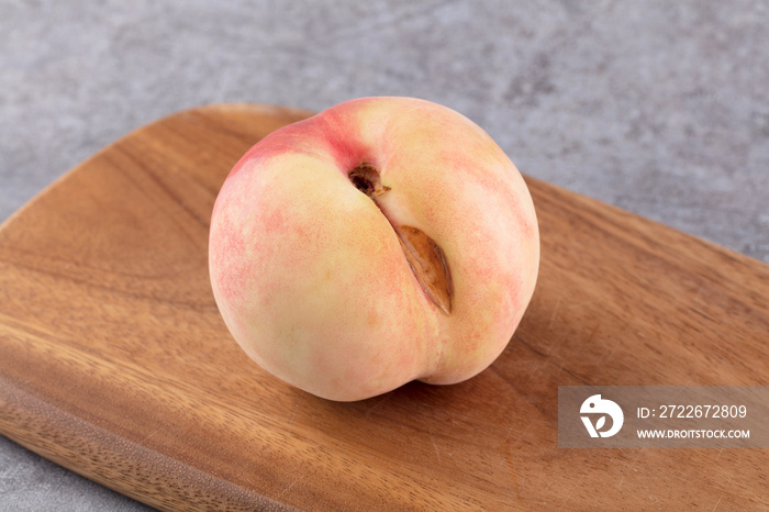 A flawed peach on the cutting board