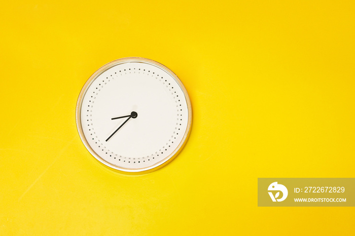 a round clock on the yellow colourful background , time is priceless concept , enjoy every seconds moment.