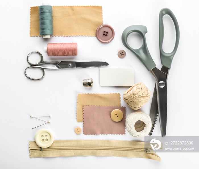 Composition with sewing threads and accessories on white background, top view