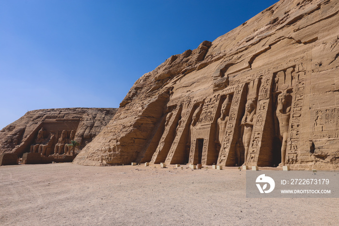 The main view of an Entrance to the Great Temple at Abu Simbel with Ancient Colossal statues of Ramesses II, seated on a throne and wearing the double crown of Upper and Lower Egypt