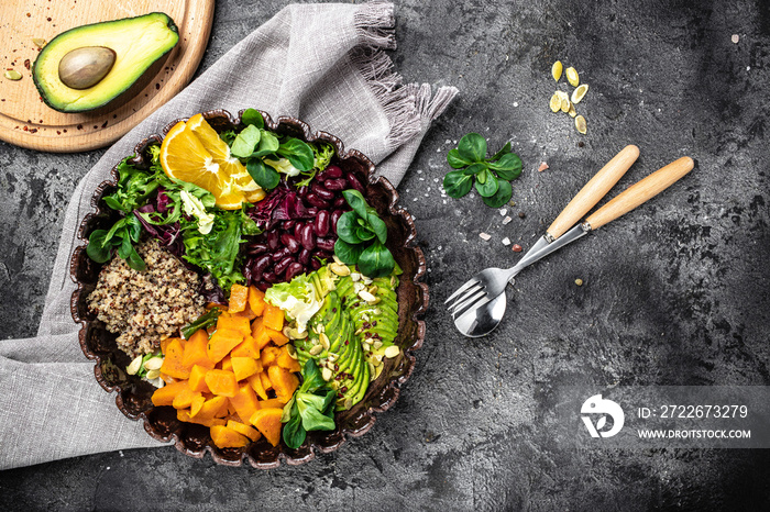 Salad with quinoa, avocado, sweet potato, beans on dark background. superfood concept. Healthy, clean eating concept. Vegan or gluten free diet. top view