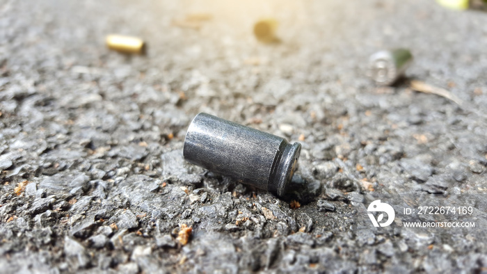 Blur empty pistol bullet shells on concrete ground in a shooting crime scene