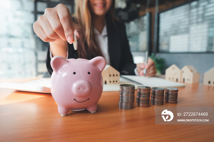 A woman’s hand holds a coin to manage money and Plan your savings to buy the best home for your family, ideas for savings, growth, economy, business and investing.