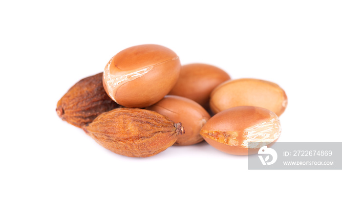 Argan seeds, isolated on a white background. Argan nuts and oil, for cosmetic and beauty products. Natural argan fruit from Morocco.