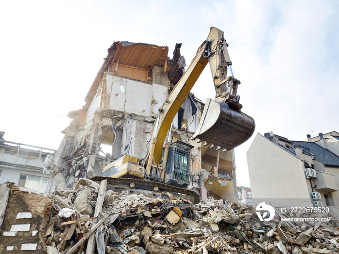 Dismantling old residential building with excavator