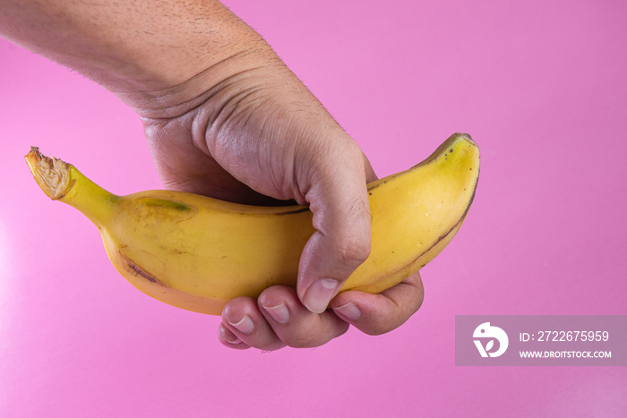 Banana on the pink background - man holding