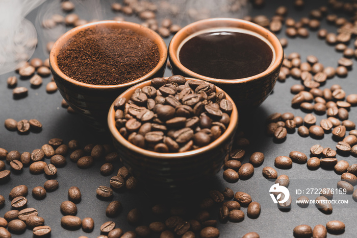 Freshly ground and prepared black coffee on a black background.