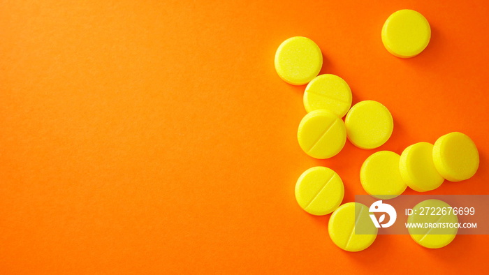 Yellow pills with copy space on orange background