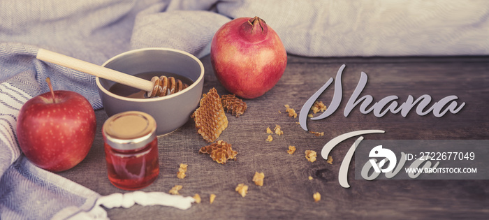 Jewish National Holiday. Rosh Hashana with honey, apple and pomegranate on wooden table. Text: Shana Tova