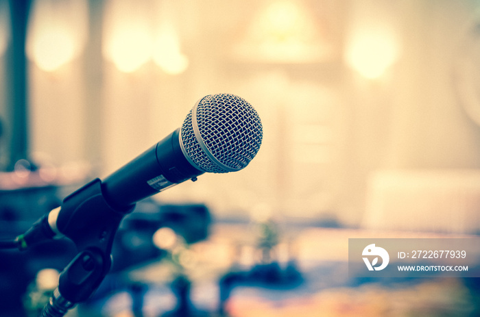 Microphone over the Abstract blurred photo of conference hall or