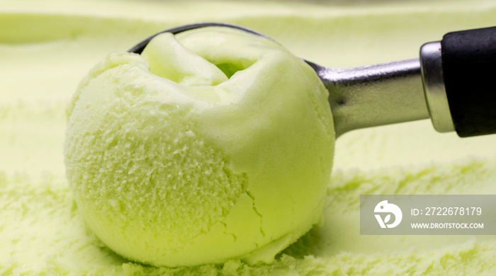 Close-up shot of green ice cream scooping with a spoon.