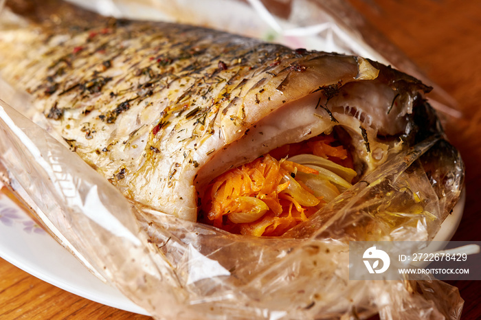 Stuffed fish with spices baked in a baking bag. Cooked seafood dishes.