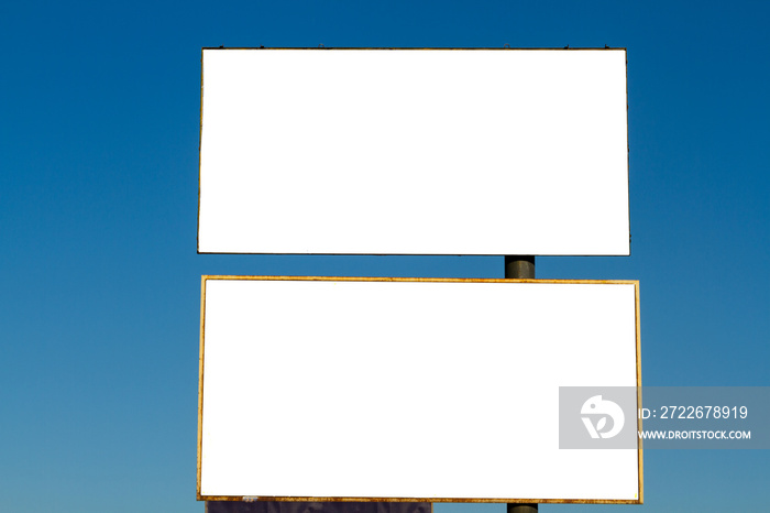 Double white billboard - white blank canvas against the blue sky. Procurement of a billboard with a blank background. City citylights with a blank background shifted to the right. Blank display.