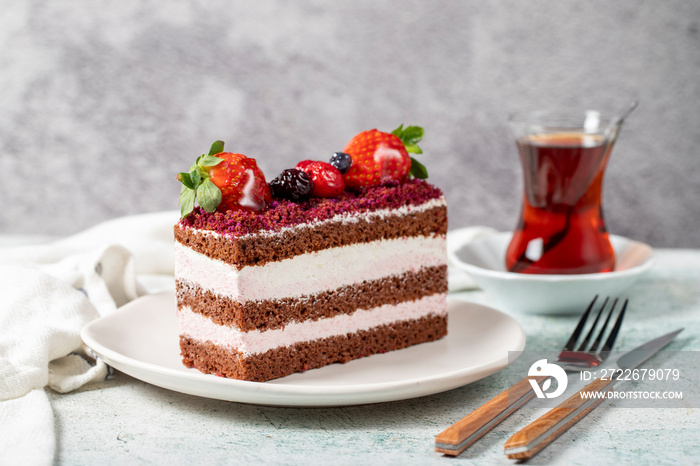 Fruit and whipped cream cake. Layered cake with forest fruit and cream on the plate. close up