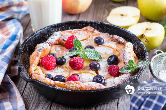 Dutch baby pancake with apple and cinnamon and fresh blueberry