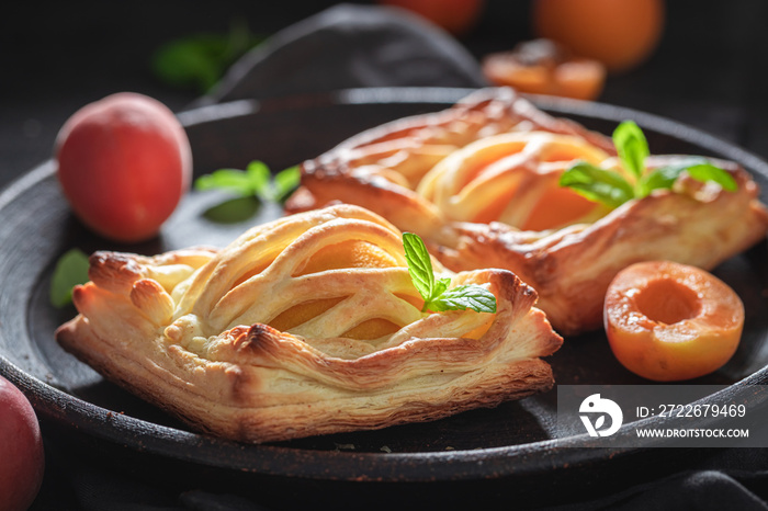 Awesome puff pastry baked with peaches. French juicy dessert.