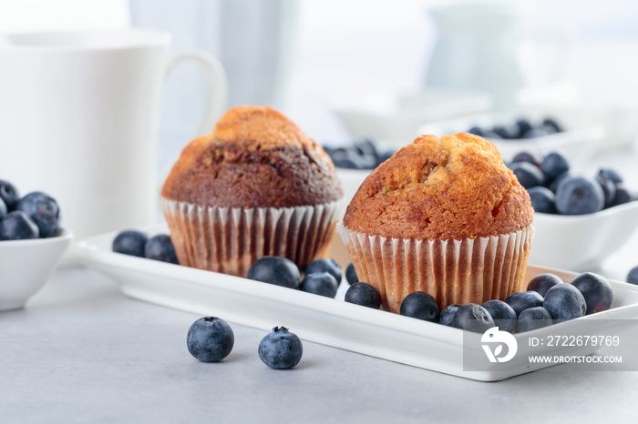 Muffins and blueberry on white table.