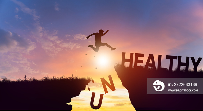 Silhouette man jumping over cliffs mountain with cloud sky and sunrise. Health and Unhealthy Concept.