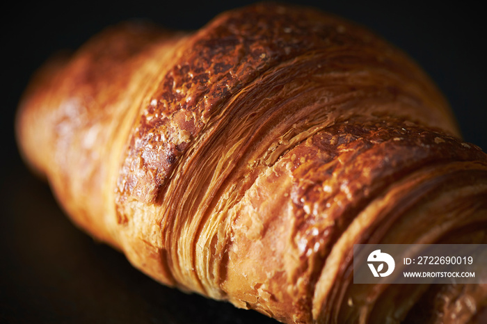 Croissant close-up, bread on black background