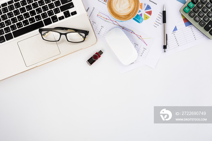 Modern White office desk table with laptop computer, eyeglasses, mouse, calculator,pen,analysis chart or graph and cup of coffee.Top view with copy space.Working desk table concept.