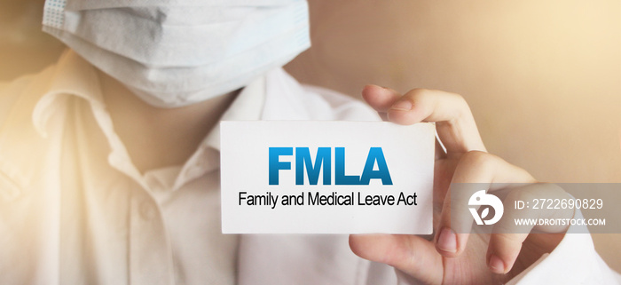 Doctor holding a card with text FMLA medical concept