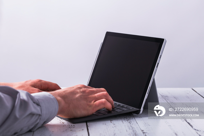 Writing male hands on laptop on the table.