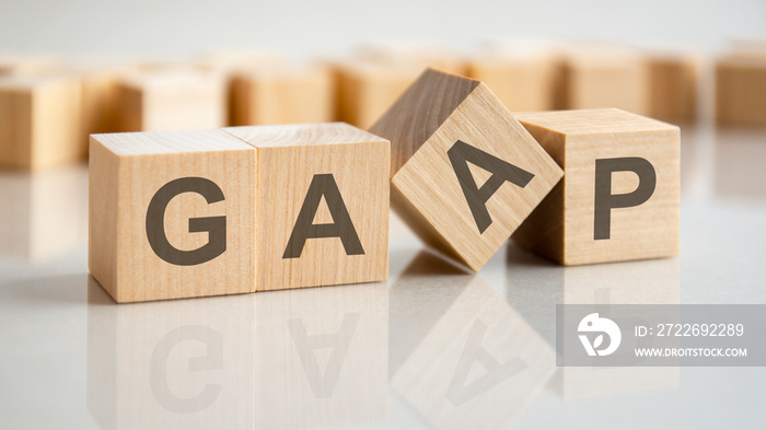 Generally Accepted Accounting Practice. GAAP the word on wooden cubes on a gray table