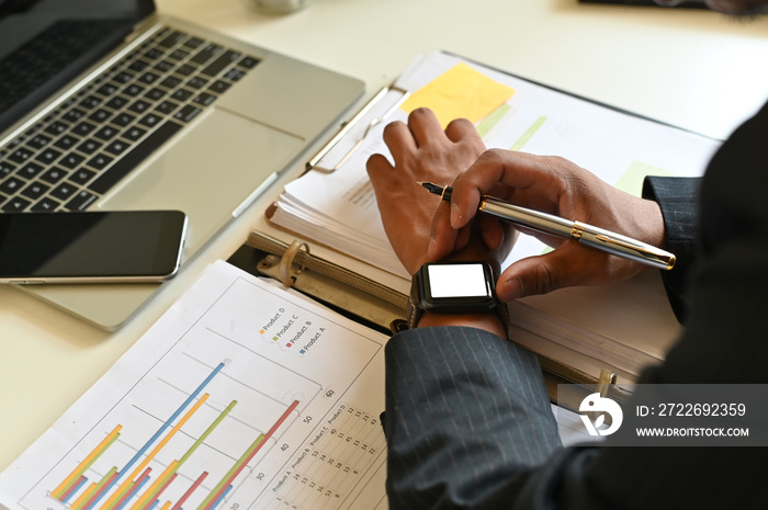 Businessman using smart watch mockup on office table.